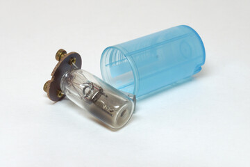 fluorescent lamp glow tube starter, diassembled, showing burned inner glass tube, filled with neon gas