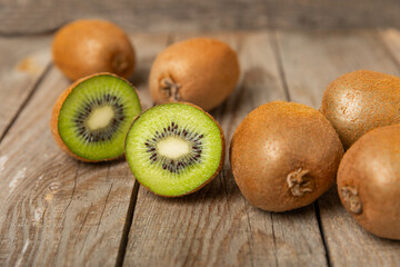 Kiwi on wooden background. Whole fruit and slices pieces of green kiwi on table. fresh ripe juicy...
