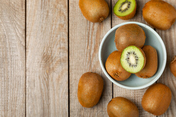 Kiwi on wooden background. Whole fruit and slices pieces of green kiwi on table. fresh ripe juicy kiwi. Tropical fruit. Organic fruit. Healthy eating. Space for text. Copy space