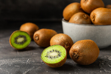 Kiwi on wooden background. Whole fruit and slices pieces of green kiwi on table. fresh ripe juicy...