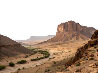 Fototapeta premium A desert landscape with a road winding through it, with a large rock formation in the background and some trees