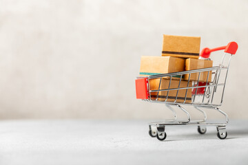 Online shopping concept.Cardboard box and shopping bags in a trolley on a bright colored...