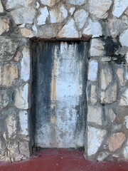 A mysterious sealed doorway or wall recess in a rustic stone facade in Andalusia, Spain. Timeworn textures and weathered details add to its enigmatic charm