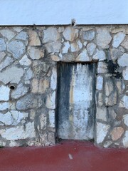 A mysterious sealed doorway or wall recess in a rustic stone facade in Andalusia, Spain. Timeworn textures and weathered details add to its enigmatic charm