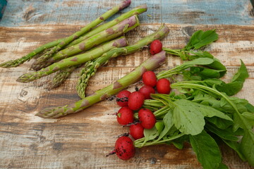garden harvest on wooden board. harvest of asparagus and ripe radishes