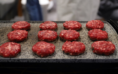 carne de hamburguesas en la plancha de asar preparadas para freír