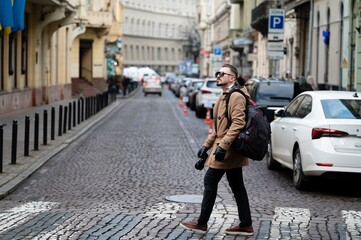 Wanderer in a bustling city street during a cool afternoon, exploring urban life and capturing...
