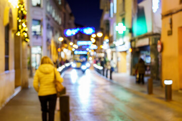 Blurred background commercial street city with Christmas lighting, blurred vacation background. Christmas lights and christmas decorations on street. For banner, designs. copy space