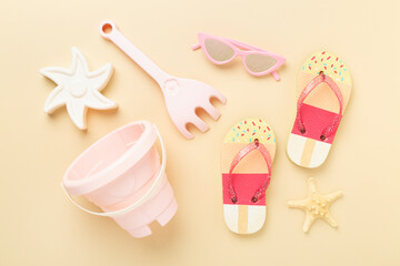 Children's flip flops and beach toys on color background,,top view
