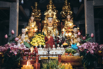The structure of a building is visible, with lush trees behind it Ninh Binh, Vietnam