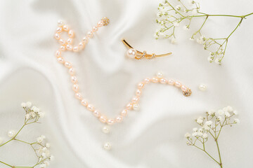 Elegant golden jewelry with decoration on textile background, top view