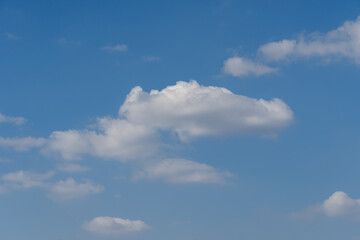 Blue sky and white clouds of nature background. Some different shapes of cloudscape. Cumulus and atmospheric mood. Contrasts weather is frowning and sunny.
