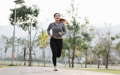 In the evening, a young woman jogs through a city park, bathed in golden sunlight and a cool breeze. Surrounded by lush trees and birdsong, she feels refreshed and relaxed.