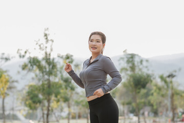 A young woman pauses during her run to tighten her shoelaces. A gentle breeze and birdsong refresh...