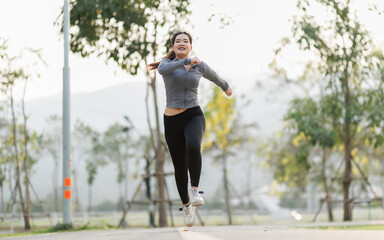 A young woman jogs purposefully in the city park, feeling joyful and energized, her mind uplifted by the refreshing atmosphere and soft sunlight.