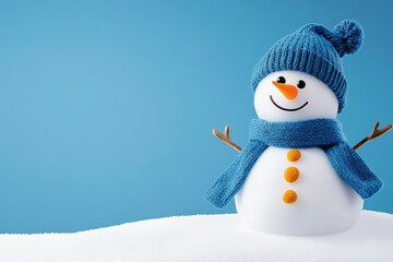 Obraz premium Cheerful Snowman in Blue Winter Hat and Scarf - A happy snowman in a blue knitted hat and scarf sits on a snowy landscape against a light blue background. Perfect for winter holidays