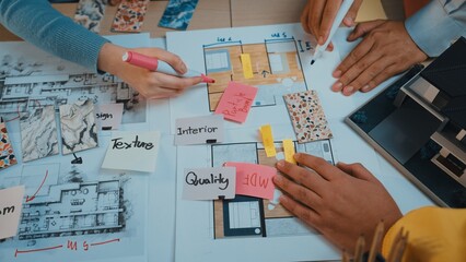 Professionals collaborate on architectural plans and design ideas, using color swatches and notes...