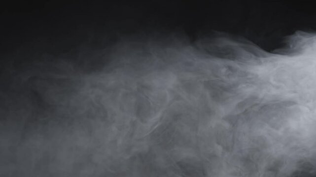 Abstract white smoke in slow motion. Smoke, Cloud of cold fog in light spot background. Light, white, fog, cloud, black background, 4k, ice smoke cloud. Floating fog.