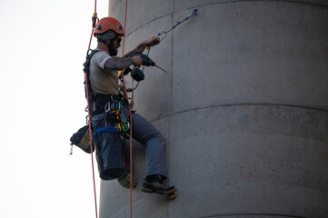 Man working on concrete chimney using power drill