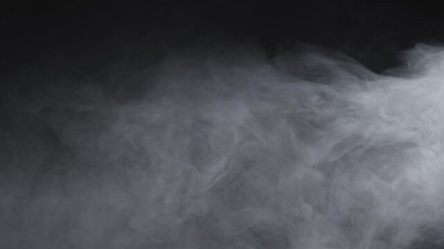 Abstract white smoke in slow motion. Smoke, Cloud of cold fog in light spot background. Light, white, fog, cloud, black background, 4k, ice smoke cloud. Floating fog.