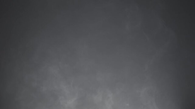 Abstract white smoke in slow motion. Smoke, Cloud of cold fog in light spot background. Light, white, fog, cloud, black background, 4k, ice smoke cloud. Floating fog.