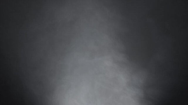 Abstract white smoke in slow motion. Smoke, Cloud of cold fog in light spot background. Light, white, fog, cloud, black background, 4k, ice smoke cloud. Floating fog.