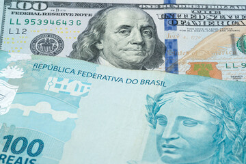 US 100 dollar and 100 Brazlilian real banknotes. International trade concept