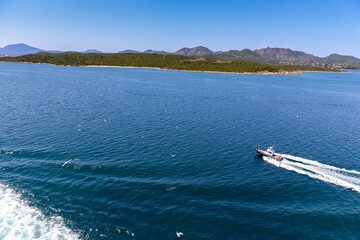 Obraz premium A boat is traveling across a large body of water near island Sardinia Italy