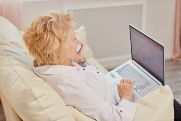 Obraz premium Senior woman comfortably using a laptop