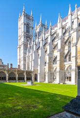 Visitors enjoy the serene green lawn at the Cloisters of Westminster Abbey in London, surrounded by...