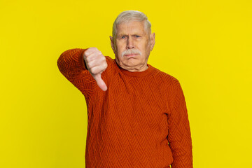Dislike. Upset unhappy senior man showing thumbs down sign gesture, expressing discontent,...