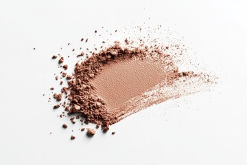 Soft brown powder spread on a white surface, showcasing texture and color variation, perfect for cosmetic applications or artistry