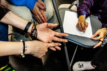 hands of teenagers, write, pen, leaf, girls, bracelets, beads, braided, painted nails, rings, children's camp, communication, discussion,