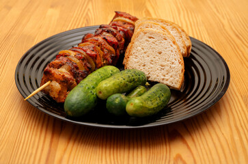 szaszłyk wieprzowy z ogórkami kiszonymi i chlebem,
pork shashlik with pickled cucumbers and bread