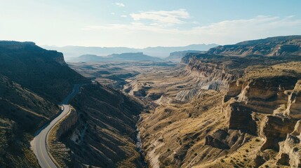 Scenic route winding through a rugged canyon landscape under a bright blue sky