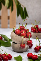 Fresh red cherries overflowing from ceramic bowls