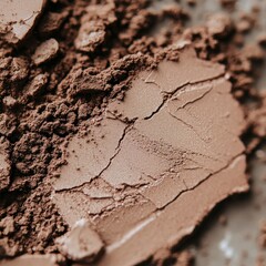 Fototapeta premium close-up of brown cosmetic powder, with visible cracks and textures, showcasing the product's details