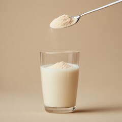 A spoonful of powder being added to a glass of milk. The powder appears to be a supplement, and the scene is clean and simple.