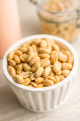 Roasted salted peanuts in bowl on kitchen table