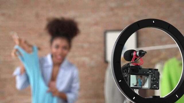Rear view behide camera screen recording woman influencer shoot live stream vlog video review clothe crucial social media or blog. Girl with apparel studio lighting for marketing broadcasting online