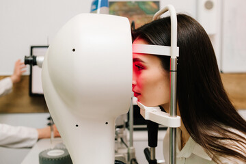 Corneal topography eye test with red light for eye health, correction, and treatment. Doctor examines cornea using advanced imaging to detect vision issues like astigmatism or keratoconus.