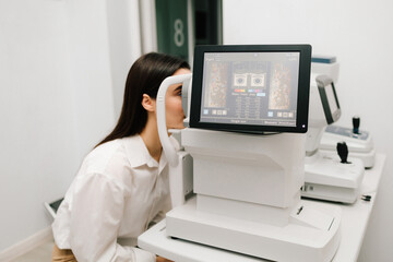 Girl undergoes an OCT eye exam using advanced optical coherence tomography equipment. The...