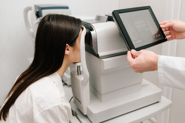 Eye exam with modern autorefractor and OCT machines. Autorefractor measures refractive errors,...