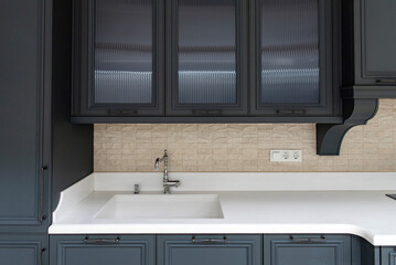 Chrome kitchen faucet with built-in sink in blue kitchen