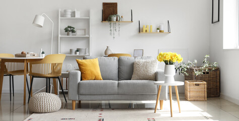 Vase with daffodil flowers on coffee table in living room