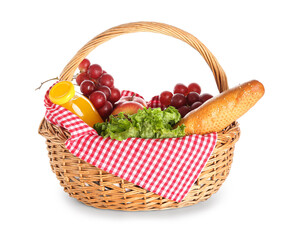 Wicker basket with tasty food for picnic and juice on white background