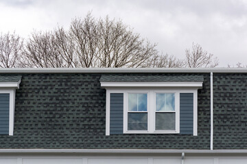 Upper portion of a residential building with dormer in Brighton, Massachusetts, USA
