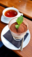 tiramisu dessert with a cup of tea on a wooden table