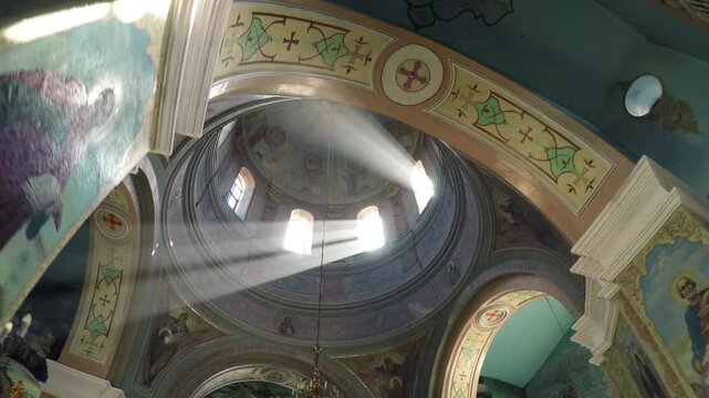Interior and wall painting of Orthodox Christian church in the rays of the sun in Ukraine 