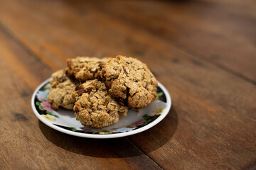 cookies, oatmeal cookies resting over a little dish plate, on a wooden table